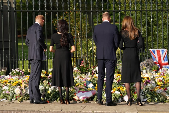 Prince Harry, Duke of Sussex, Meghan, Duchess of Sussex, Catherine, Princess of Wales and Prince William, Prince of Wales view floral tributes left at Windsor Castle following the death of Her Majesty The Queen. (Photo by Kirsty O'Connor - WPA Pool/Getty Images)