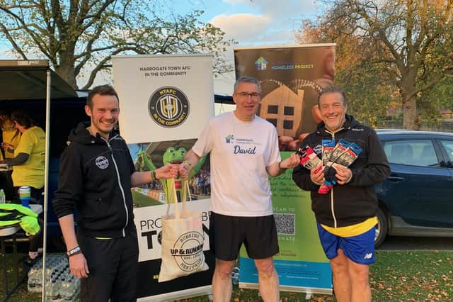 Supporting charity - Jeff Walker of Up & Running Harrogate, right; and David, Harrogate store manager, left; in present the socks to David Thomas from the Harrogate Homeless Project.