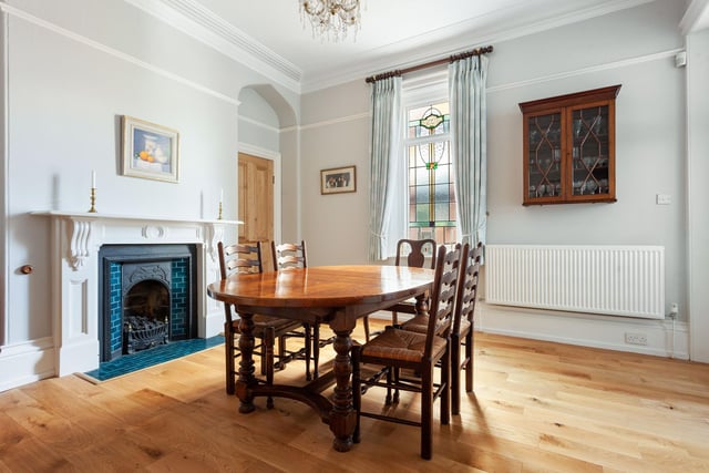 The dining room has a stunning stained glass window and a Victorian fireplace.