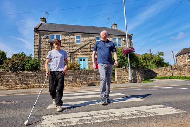 Archie crosses a road with support from Guide Dogs Habilitation Specialist Andrew