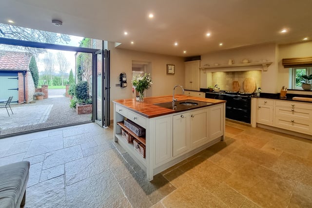 The high spec kitchen with central island has bi-folding doors to the courtyard.