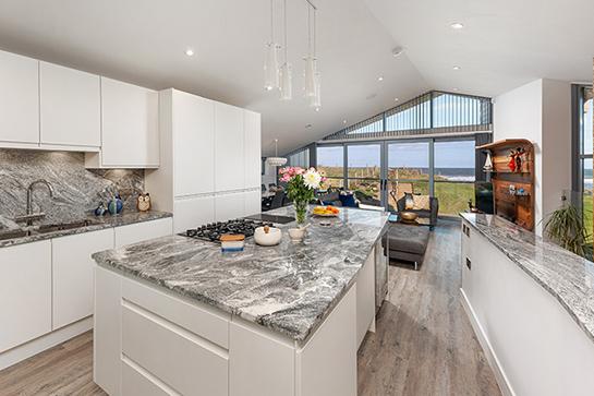 A superbly appointed contemporary fitted kitchen, complimented by granite worktops, splashbacks, and under unit lighting, which extends to a large central island, as well as numerous integrated appliances.