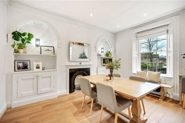A bright dining room with feature fireplace and display niches with plaster moulding.