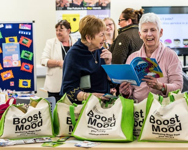 Home library service volunteers, Jennie Leitch (left) and Annabel Garnett, looking through the resources included in the wellbeing bags.