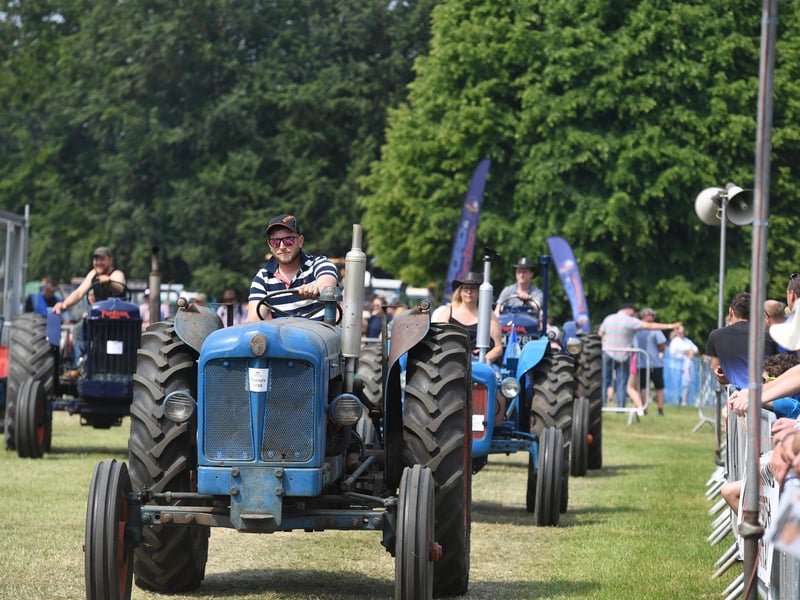 The vintage tractors on parade in the main ring at the show