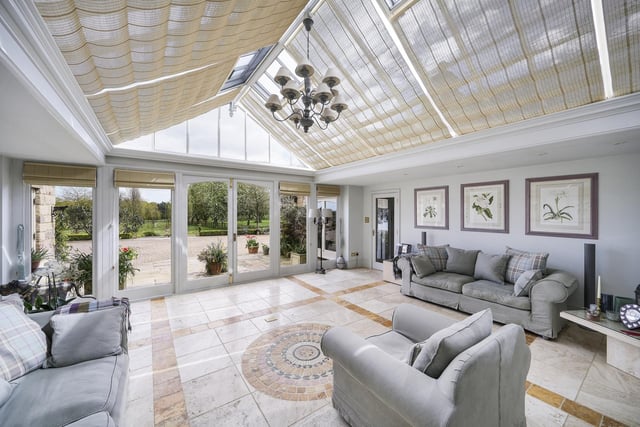 This spectacular garden room has a glass ceiling and French doors out to the gardens.