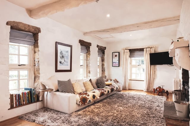 The properties large sitting room has a feature fireplace and a cast iron stove.