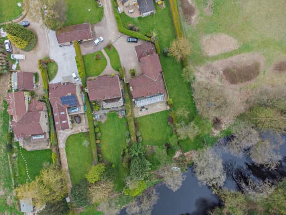 An aerial view of the house and gardens that stretch to the banks of the river.