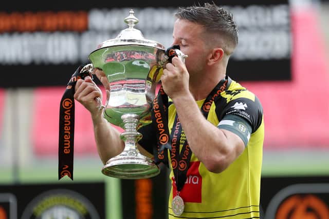 Josh Falkingham lifts the National League play-off final winners' trophy following Harrogate Town's 3-1 success over Notts County at Wembley Stadium. Picture: Catherine Ivill/Getty Images
