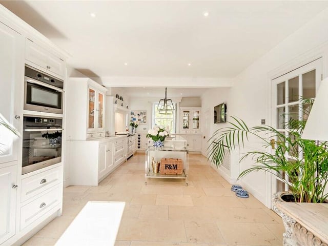 An immaculate kitchen has a large central island.