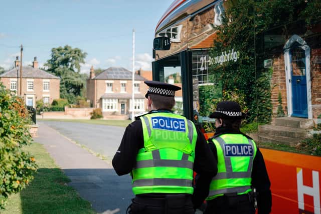 Two Harrogate police officers walk by a 21-bus operated by the Harrogate Bus Company. (Picture contributed)