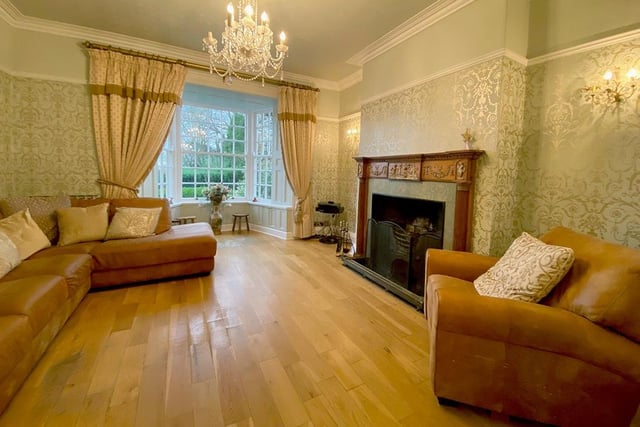 A reception room with a stunning bay window and feature fireplace.