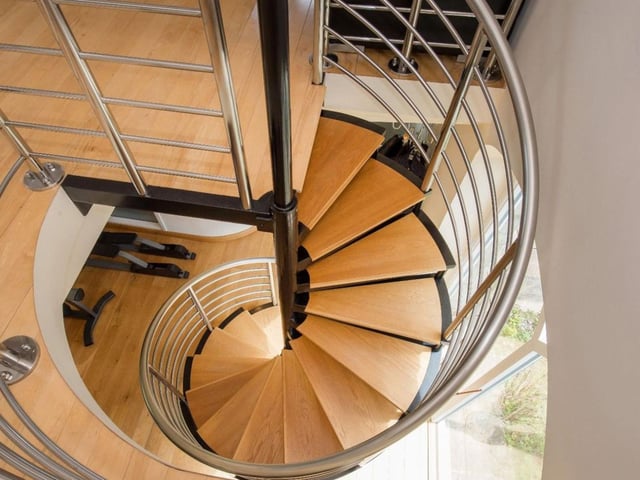 A spiral modern staircase leads on from the private gym to a separate living space.