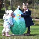 Two-year-old Libby Hewick and four-year-old Maddie Simpson with one of the giant eggs