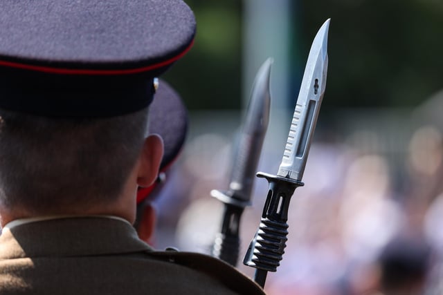 A junior soldier carries a rifle with a fixed bayonet during the graduation parade