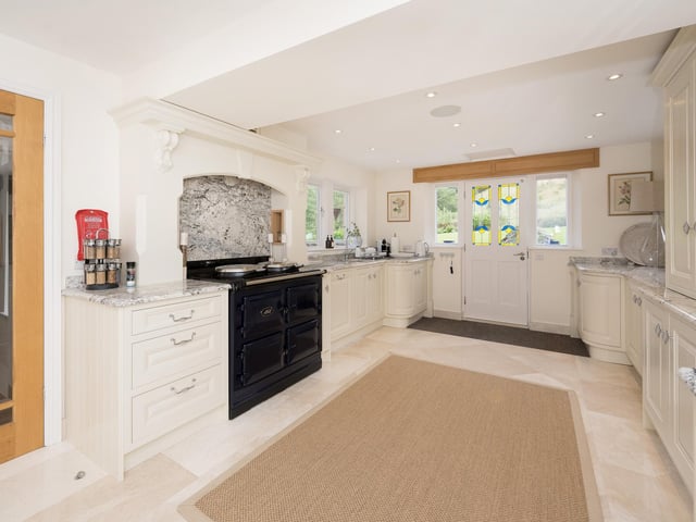 The spacious, modern kitchen with dining area has two sets of doors to outside.