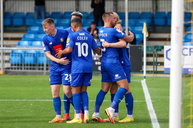 Harrogate Town striker Luke Armstrong, far right, is congratulated after converting his penalty at the end of the first half to make it 1-1.