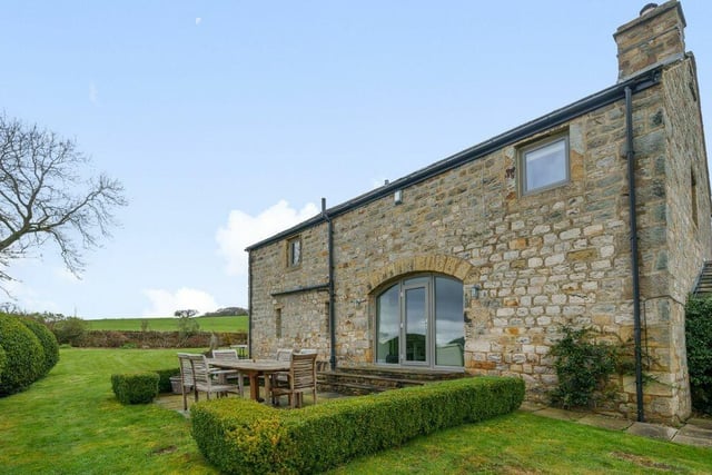 Lawned and enclosed gardens with country views include a sizeable seating area.
