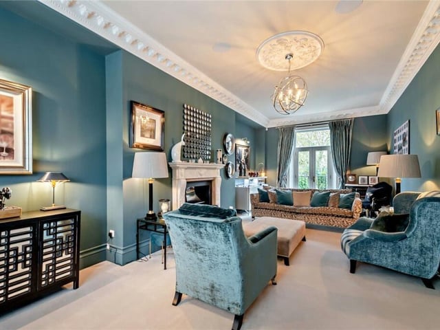 A stunning reception room with a large feature fireplace and French doors to outside.