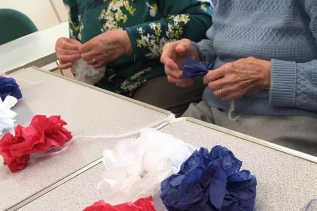 ​Members of Young at Heart making pom poms for their celebrations.