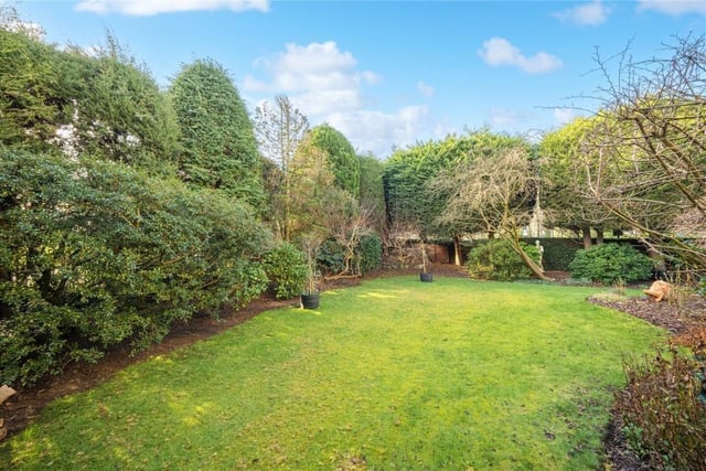 The established lawned garden has a selection of mature trees, shrubs and bushes.