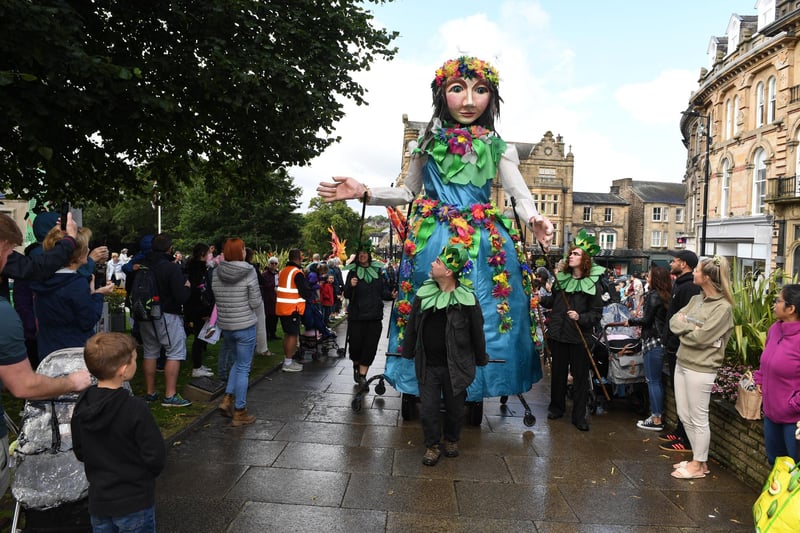 Giant puppeteers in the parade make their way through the centre of Harrogate towards the Valley Gardens