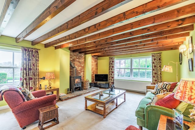 A beamed sitting room with warming stove.