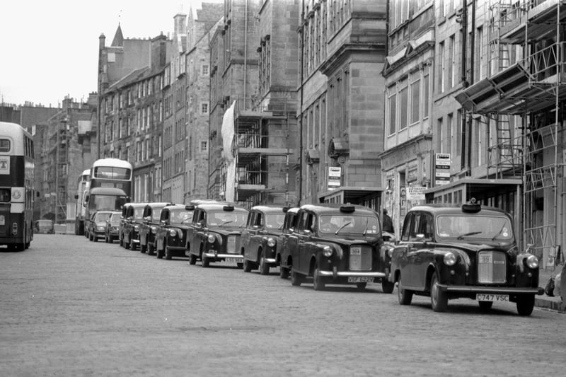 A convoy of black taxis makes its way down the Royal Mile in a protest against the proposed increase in the number of Edinburgh cabs. Picture taken March 1987.