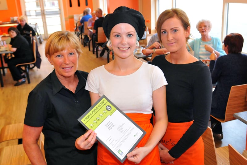 Eugene's cafe staff  member Beth Wilkinson holds the Food Hygiene certificate as fellow staff members look on in 2013.