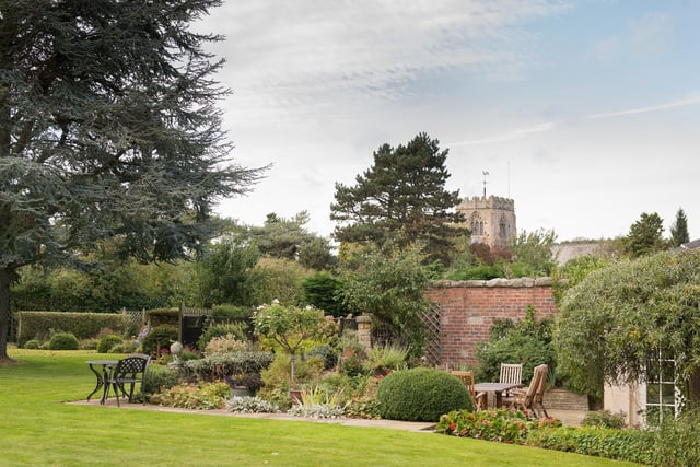 The house, close to the village's historic church, has mainly walled gardens.