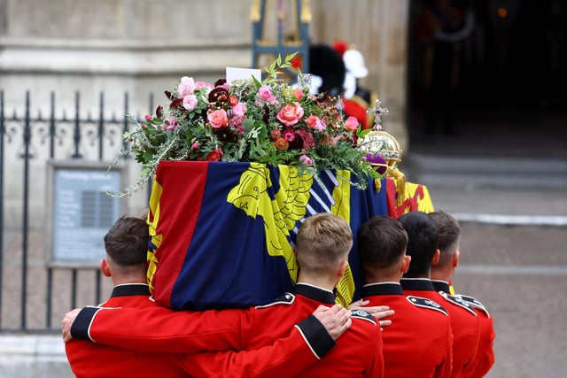 The coffin of Britain's Queen Elizabeth is carried into the Westminster Abbey during the state funeral and burial of Queen Elizabeth II at Westminster Abbey. (Photo by Hannah McKay- WPA Pool/Getty Images)