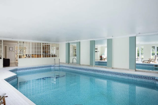 The property boasts a bespoke fully fitted bar leading to a large indoor heated pool which features mosaic tiling.