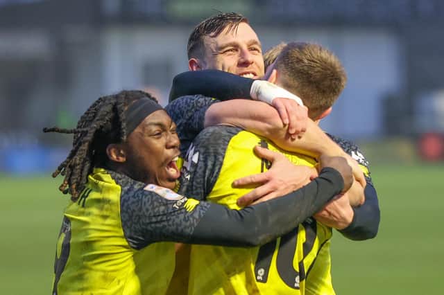 Harrogate Town striker Jack Muldoon, centre, celebrates his late winner against Colchester United with Abraham Odoh and Matty Daly. Pictures: Matt Kirkham