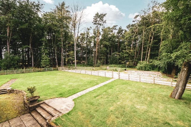 The barn is surrounded by a large fully fenced grassed area, and a further area of woodland.