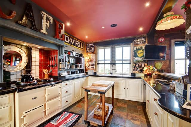 Inside the fitted kitchen, with an Aga, that flows through to a dining area, with double doors out to a patio.