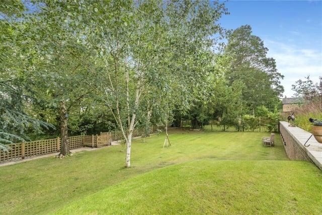 A view across the lawned garden, with mature trees.