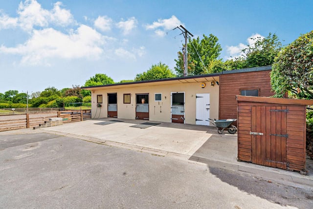 Three stables with tack and feed rooms form the stable block, adjacent to the menage and paddocks.