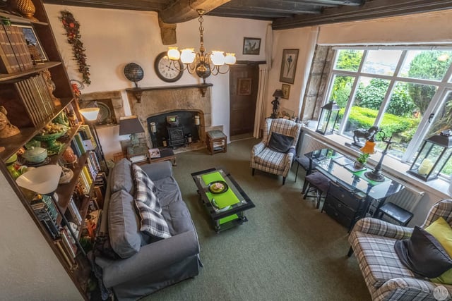 A beamed living room with stone fire surround and lovely views through the window.