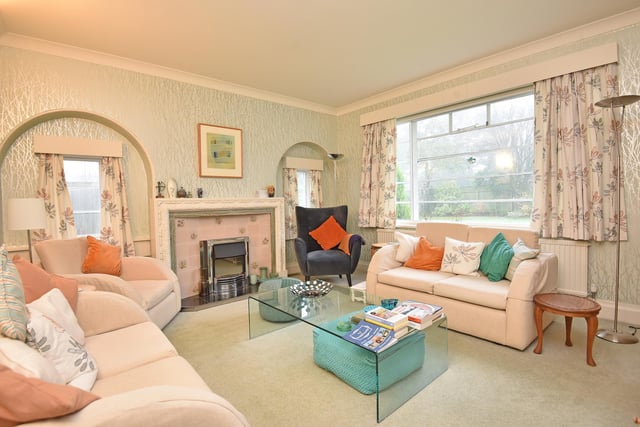 Arched designs feature strongly throughout the property, as in this sitting room with a focal fireplace.