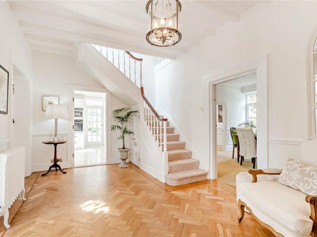 The light and welcoming hallway has a staircase leading up to the first floor.