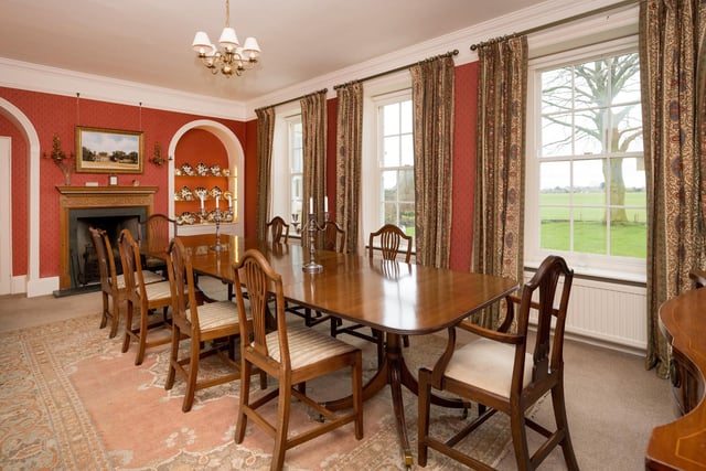 A bright and sizeable dining room with fireplace and period decorative detail.