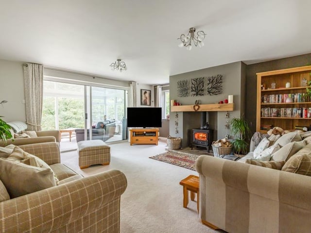 A log burning stove is a central feature in this large living room.