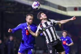 Harrogate Town midfielder Alex Pattison competes for a header during Tuesday's League Two clash at Grimsby Town. Pictures: Matt Kirkham
