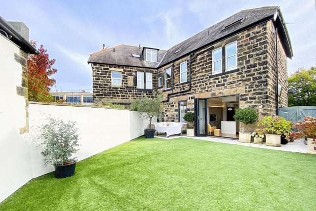 An attractive walled garden with patio and artificial lawn.