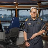 Commander Yvonne Gray from Harrogate stands of the bridge of HMNZS Manawanui. She is holding a Maori ceremonial adze, a toki poutangata.