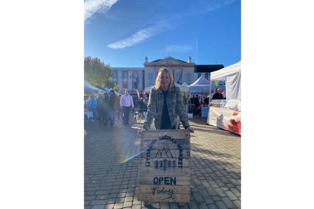 Pictured: Found Jackie Crozier proudly poses with the Little Birds Market sign, at Ripon Market Square.