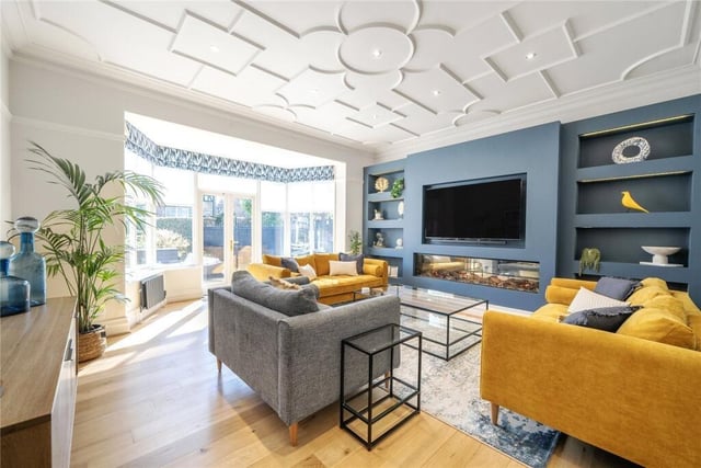 A spacious living room with media wall and access to the garden.