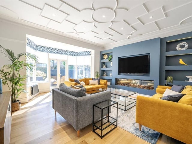 A spacious living room with media wall and access to the garden.