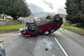 A major road in the Harrogate district was forced to close after a car ended up on its roof following a collision