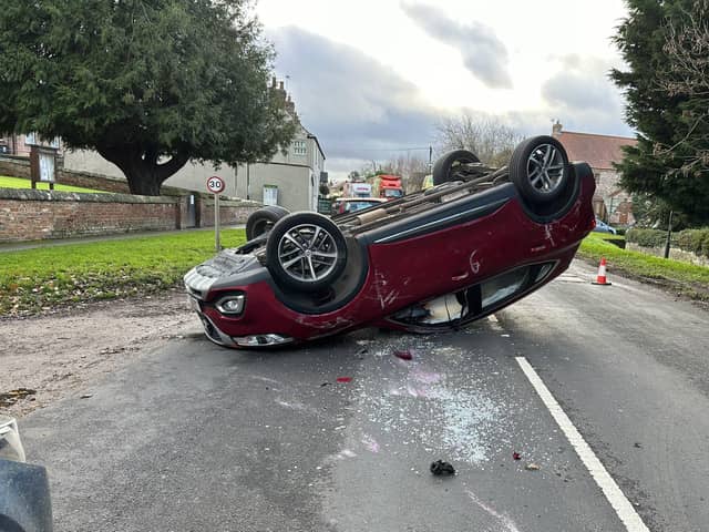 A major road in the Harrogate district was forced to close after a car ended up on its roof following a collision